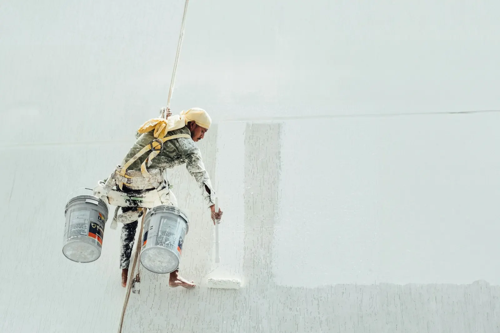 Rope-access painter working on a commercial building exterior