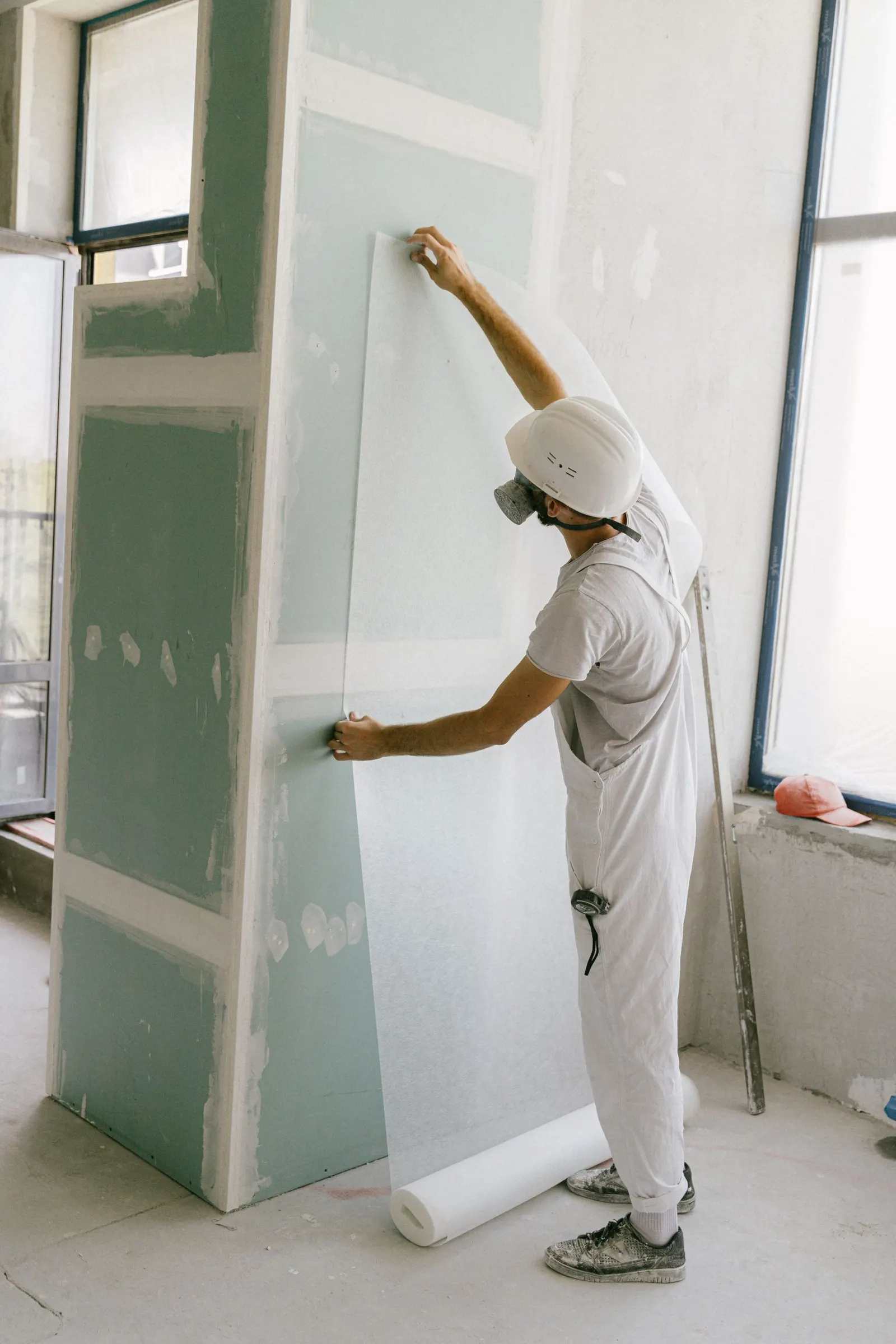 Worker smoothing wallpaper onto a wall